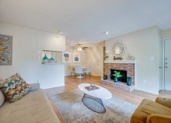 a living room with a fireplace and a couch and a table at Indian Creek Apartments, Texas