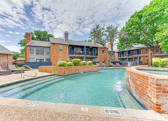 A pool surrounded by a brick wall with a "No Diving" sign.
