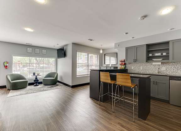A modern kitchen with a bar stool and a chair.