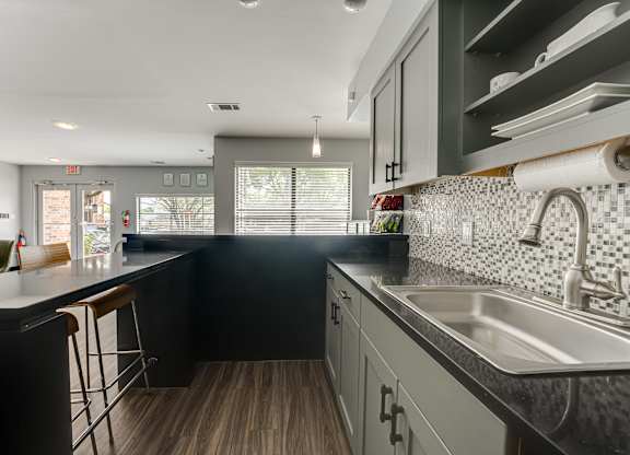 A kitchen with black cabinets and a white countertop.