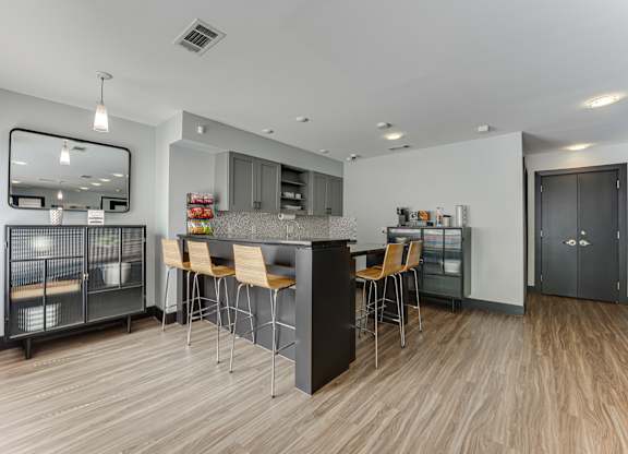 A modern kitchen with a wooden floor and a large island with chairs.