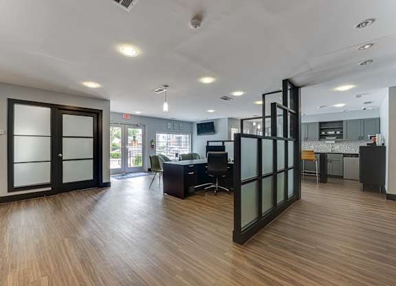 A modern office space with wood flooring and glass walls.