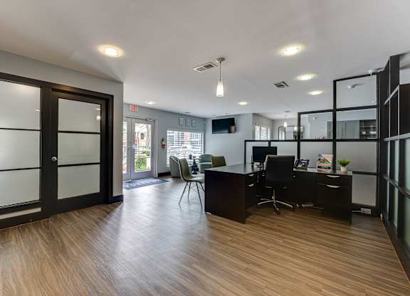A modern office space with a wooden floor and glass walls.