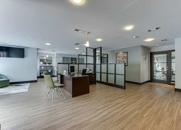 A modern office space with a wooden floor and a green chair.