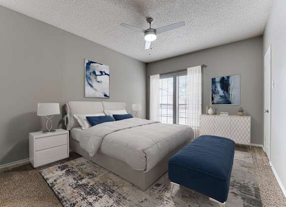 A bedroom with a bed, nightstand, and a ceiling fan.