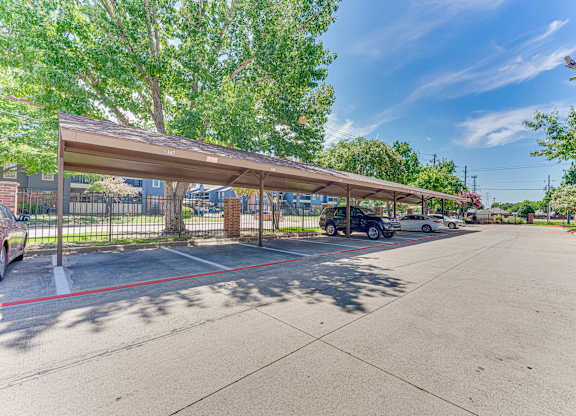 parking lot with a covered area at Timberglen Apartments, Dallas