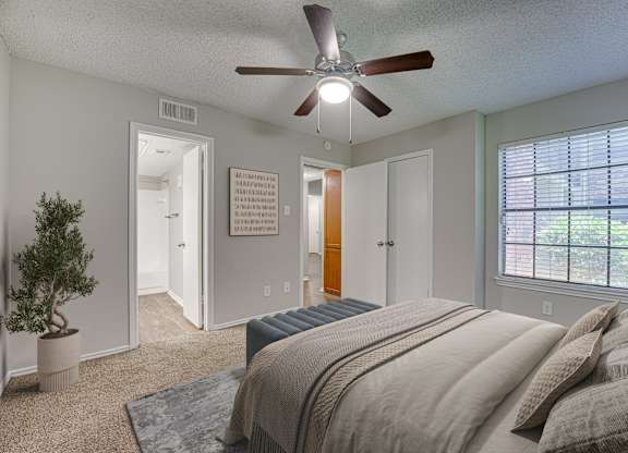 Bedroom with ceiling fan, and a potted plant. at Timberglen Apartments, Texas