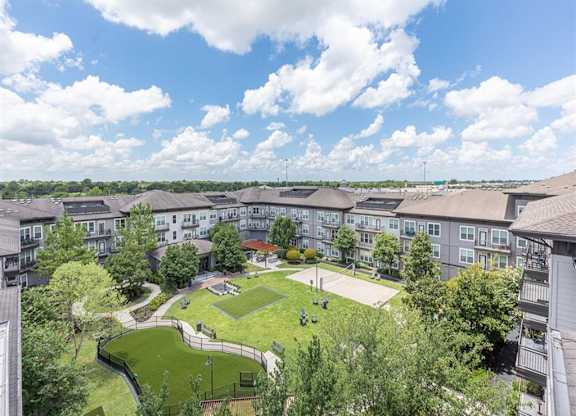 Aerial view of courtyard with green space and pathways at Highline Urban Lofts Apartments, Texas, 77429