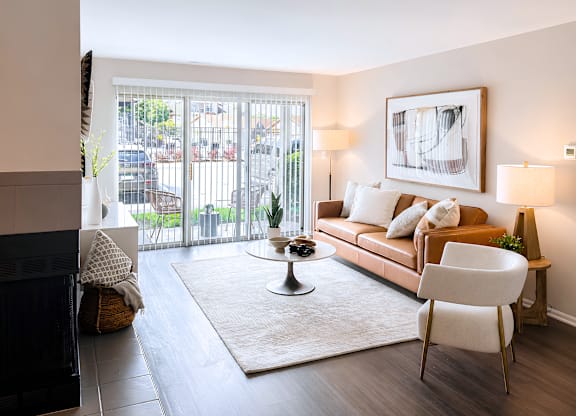 A modern living room with a fireplace and a large window.