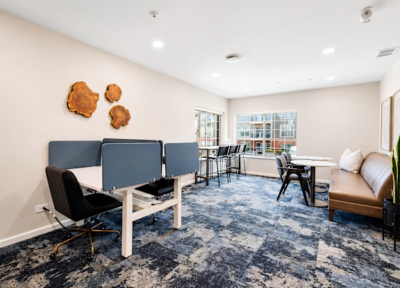 A room with a blue carpet and a white table with chairs.