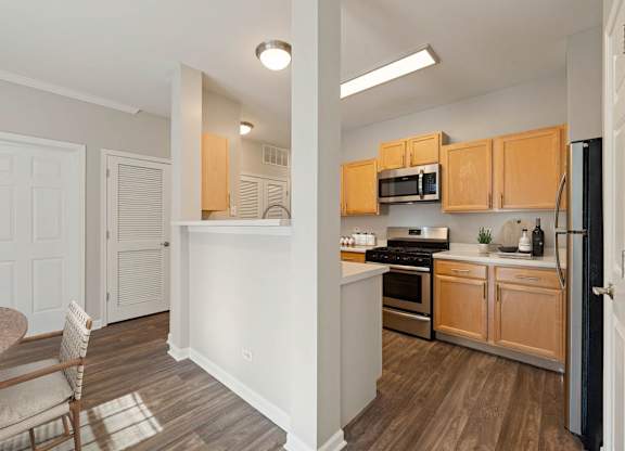 A kitchen with wooden cabinets and a dining table.