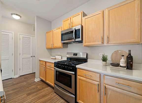 A kitchen with wooden cabinets and a stainless steel oven.