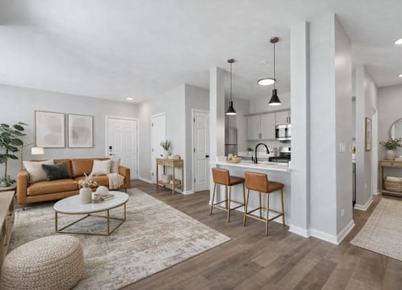 A well-lit, modern living room with a kitchen area in the background.