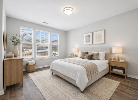 A bedroom with a large bed and a window with blinds.