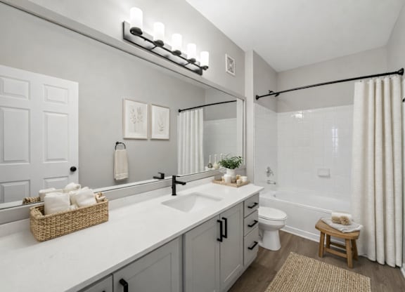A bathroom with a white sink and a white toilet.