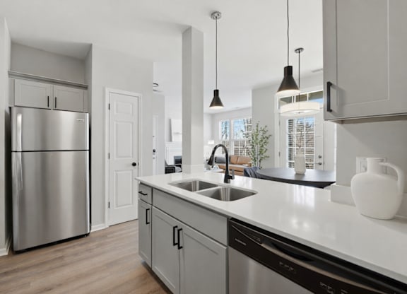 A modern kitchen with a stainless steel refrigerator and a white countertop.