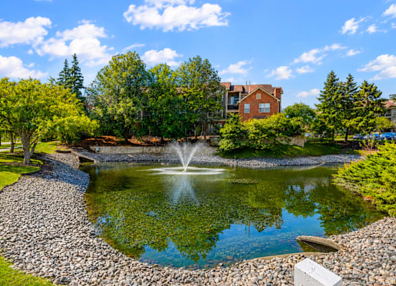 A pond with a fountain in the middle of it.