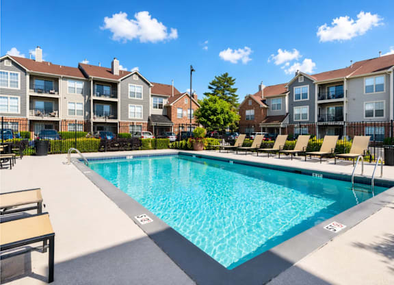 A swimming pool in front of apartment buildings.