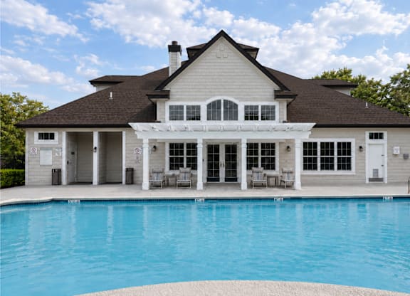 A large house with a pool in front.
