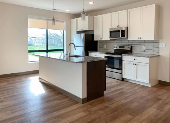 a kitchen with white cabinets and granite countertops