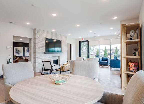 a table surrounded by chairs in the clubhouse lounge space