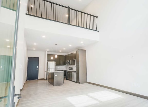 a view of the living room, kitchen, and upper loft area from the patio door