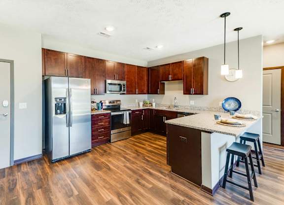 A kitchen with wooden floors and a white island.