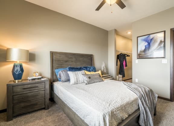 Bedroom with ceiling fan, walk-in closet and master bath at 360 at Jordan West best new apartments West Des Moines IA 50266