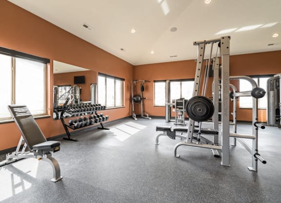 Fitness center with free weights, weightlifting machines and cardio equipment at at 360 at Jordan West best new apartments West Des Moines IA 50266