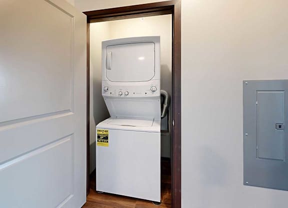 A stacked full size washer and dryer in a closet.