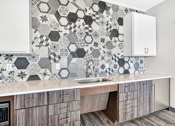 A kitchen with a tile backsplash and wooden cabinets.