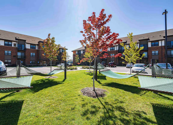 hammocks in the grass in front of an apartment building