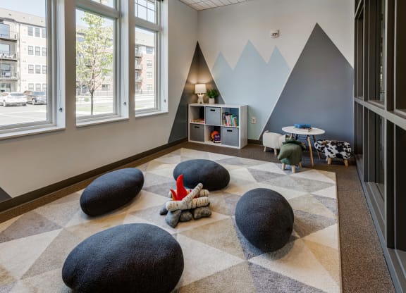 Kids room with storage shelf, plush seating and a toy fire