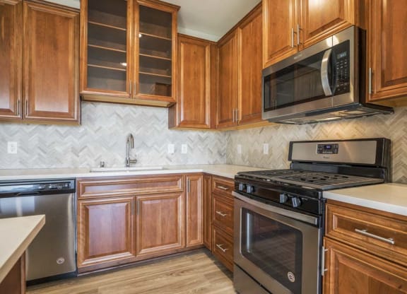 Premium design scheme with custom cabinetry and herringbone backsplash at Ascend at Woodbury MN 55129 new luxury apartments