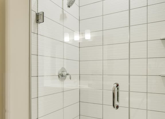 Shower with subway tile and glass doors at Ascend at Woodbury in MN