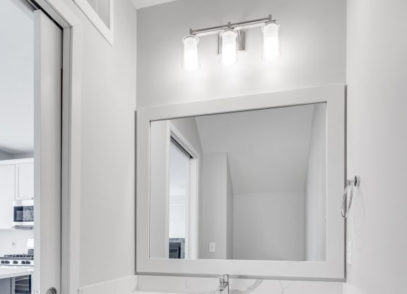 Bathroom vanity with light gray finishes and large mirror at Aspire at CityPlace in Woodbury, Minnesota