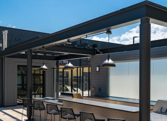 Outdoor cooking area with ample counter space and six bar stools at the bar at Aspire at Cityplace