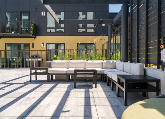 Outdoor lounge area with large sectional and 3 side tables at Aspire at CityPlace