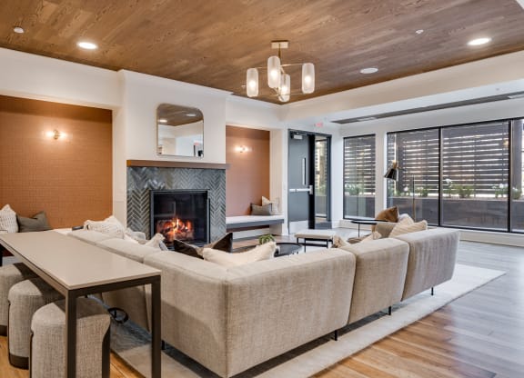 Community room with lit fireplace and comfortable couch seating at Aspire at CityPlace