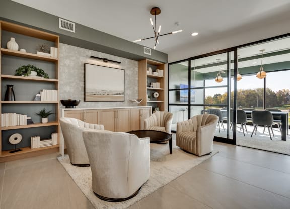 Community sitting area with chairs and built in shelving and connected conference room