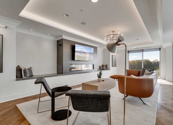 Community lounge space with electric fireplace and balcony at Aspire at CityPlace