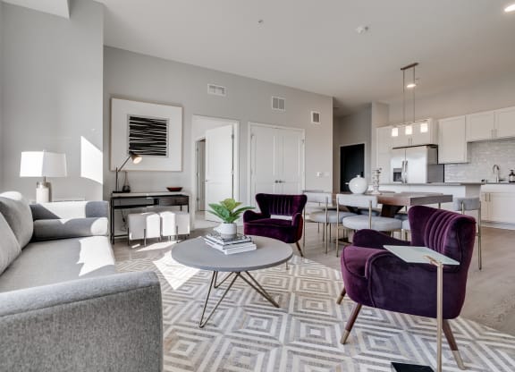 Furnished living room with high ceilings looking into the kitchen at Aspire at CityPlace Woodbury MN 55125