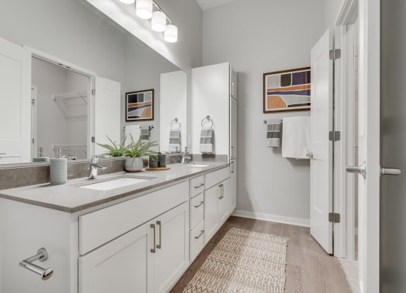 Bathroom with dual vanities and French doors in a luxury two bedroom apartment in Woodbury MN 55125