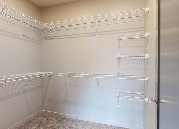 a walk-in closet with built-in wire shelves and hanging space