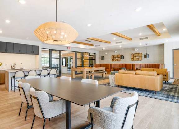 A clubroom with a dining area next to a kitchenette and lounge area that residents can rent out for private events.