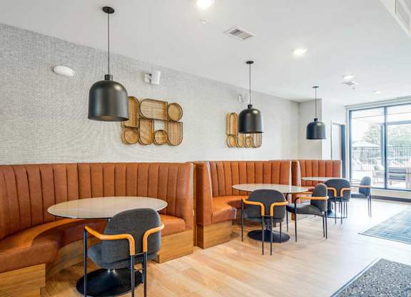A clubroom with a modern seating area with half-circle leather booths, perfect for working or study spaces.