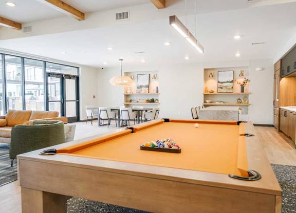 A clubroom with a orange felt pool table.