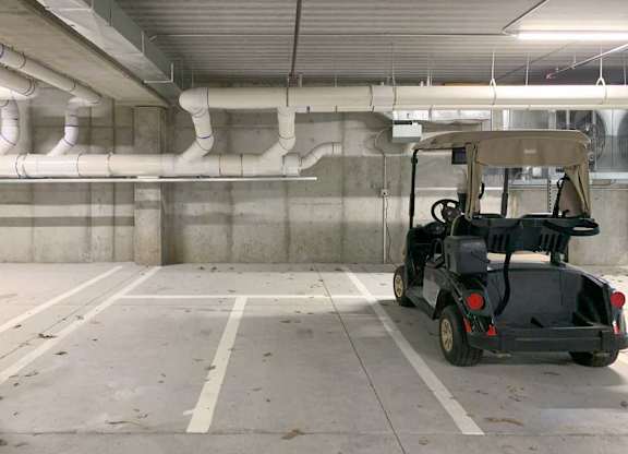 a golf cart parked in a dedicated space in the underground climate-controlled garage
