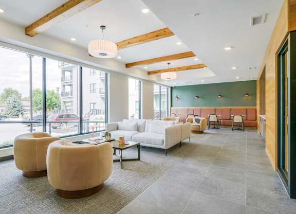 a modern, cafe-style lounge with armchairs, couches, tables and chair, and a coffee bar