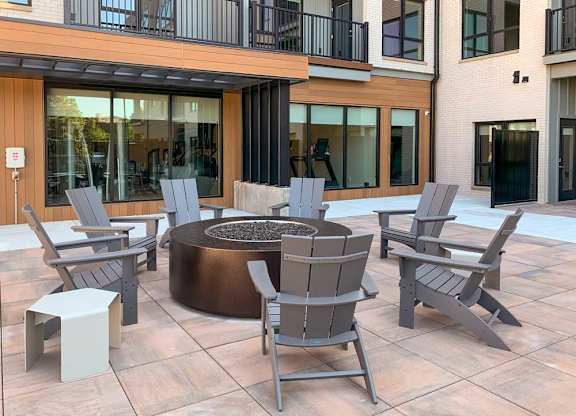a firepit with several Adirondack chairs surrounding it